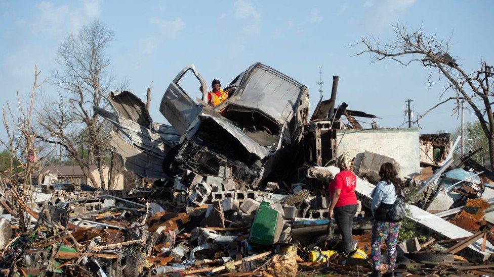 A man tries to salvage items from a car