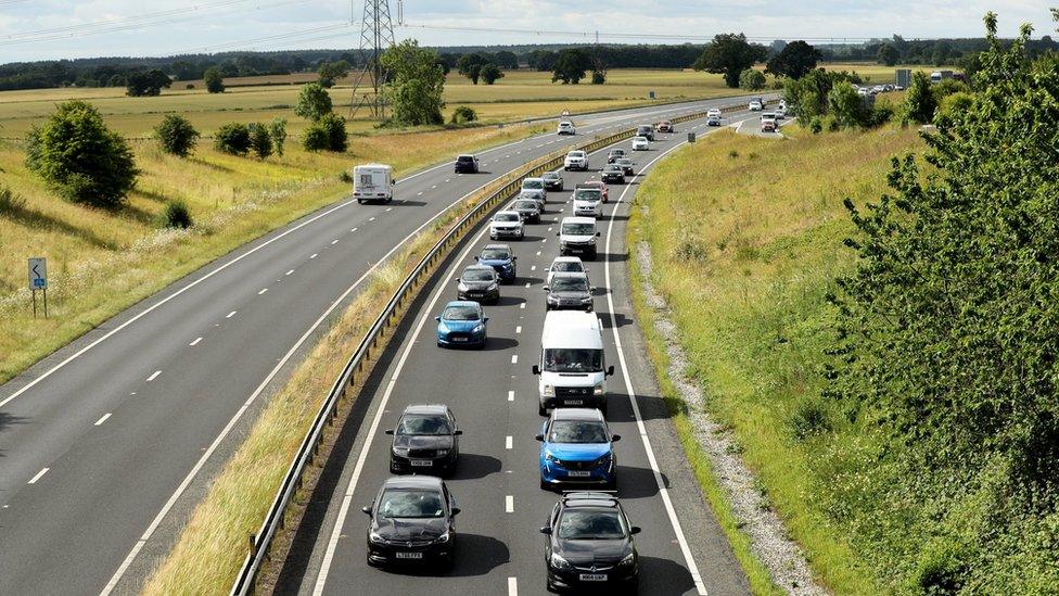 cars moving slowly along a stretch of motorway causing a traffic jam