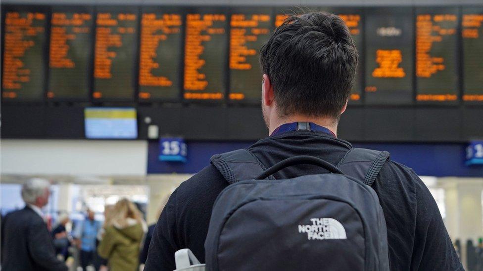 Rail traveller looking at departure board