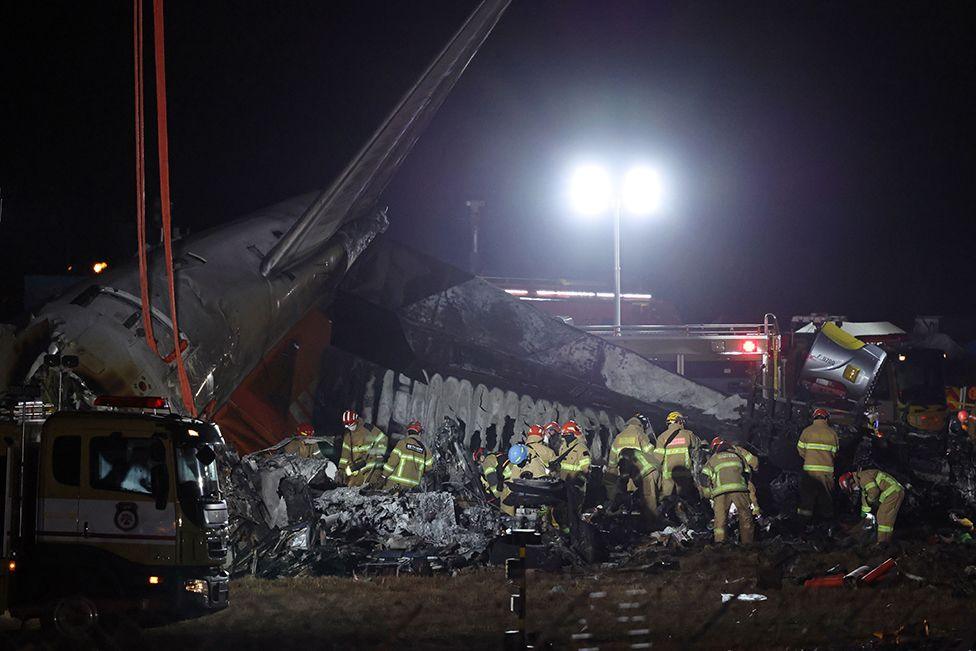 Firefighters work near the wreckage of a Jeju Air aircraft at Muan International Airport in Muan, South Jeolla province, South Korea, 29 December 2024. 