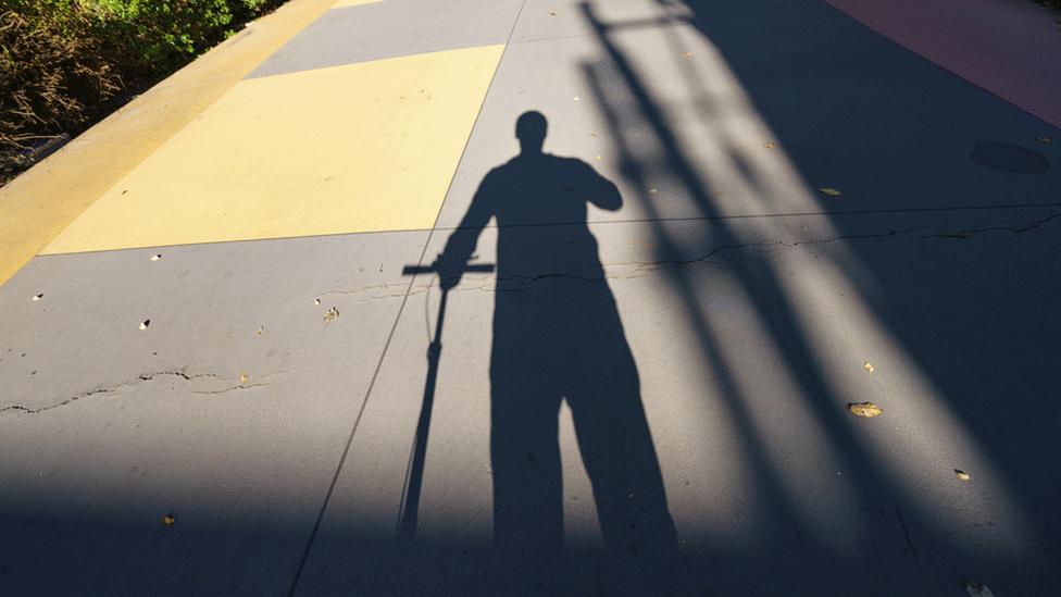 Man on scooter in silhouette