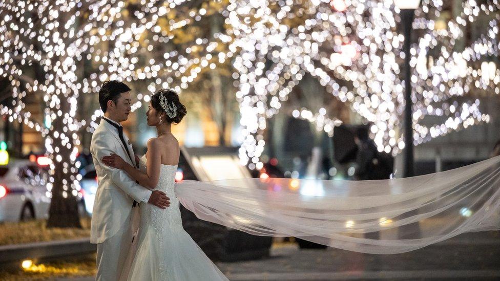 A couple pose for a wedding photo shoot in Tokyo in December 2020.