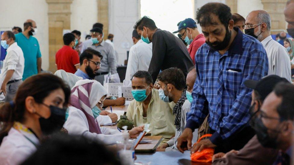 People gather to receive their coronavirus disease (COVID-19) vaccine doses, at a vaccination center in Karachi, Pakistan April 28, 2021