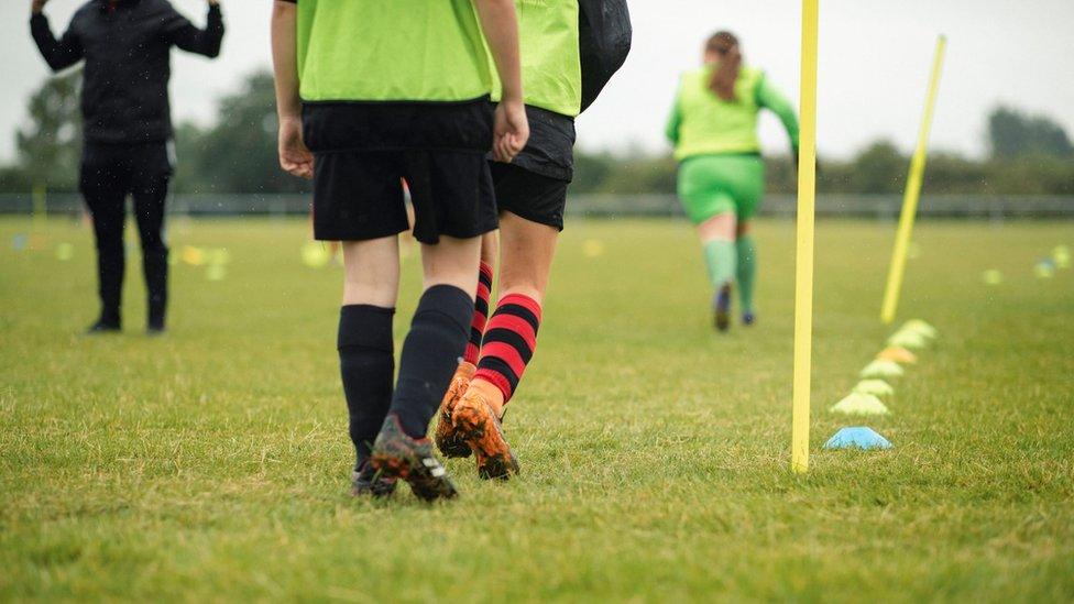 A low angle view of a group of teenagers practising football training drills