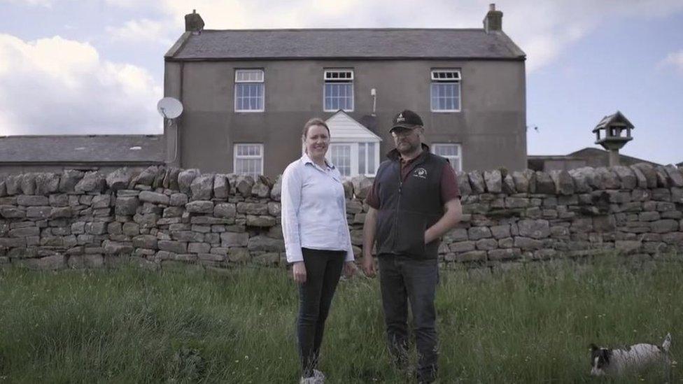 A couple, Sarah and Neil Robson standing outside their remote farmhouse