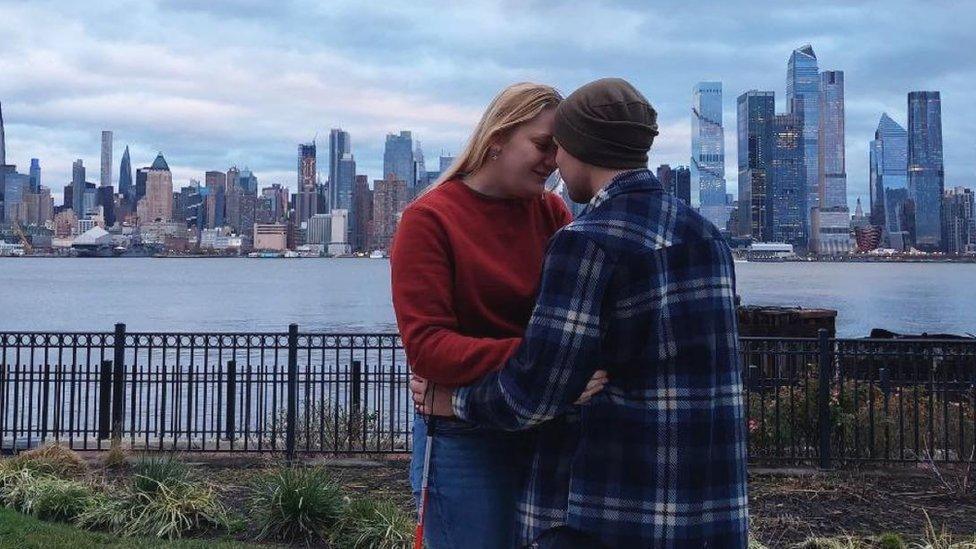 Serhiy and his wife in front of a city skyline