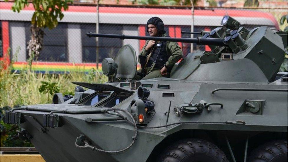 A an armoured tank from the Venezuelan army drives along a highway in Caracas as an operation to capture Oscar Perez