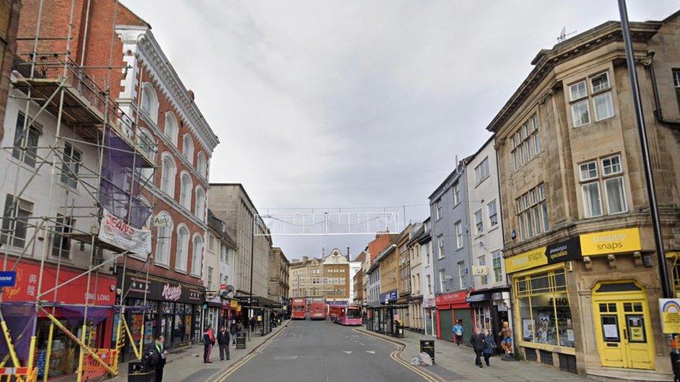 Shopping street in Northampton showing various small stores