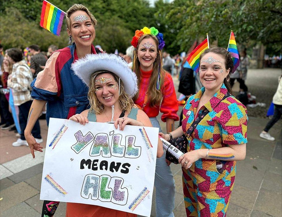 Women in rainbow cowboy outfits