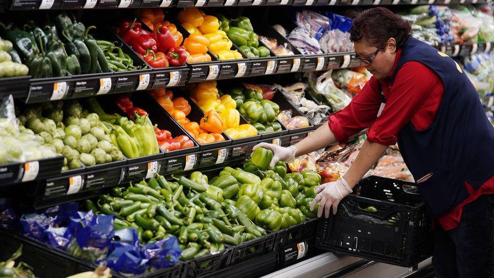 Walmart employee stacks vegetables