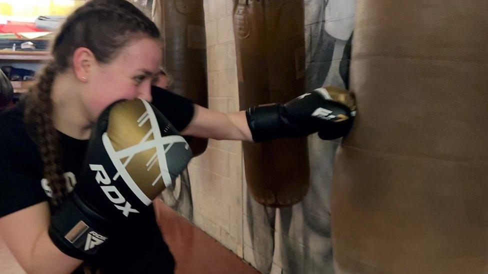 A woman hitting a punching bag