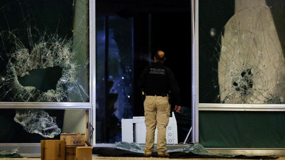 A police officer inspects damage at the Supreme Court