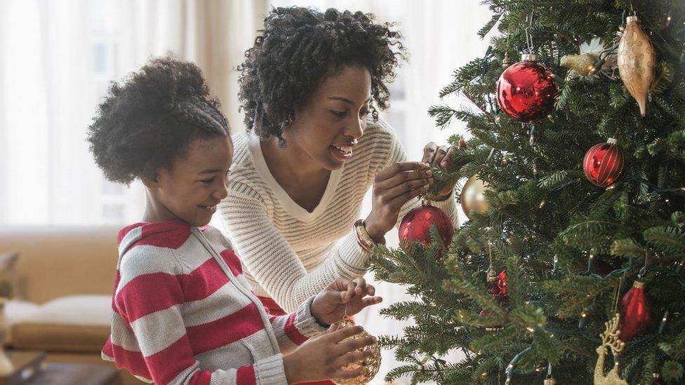 A mum and a daughter putting up their Christmas decorations