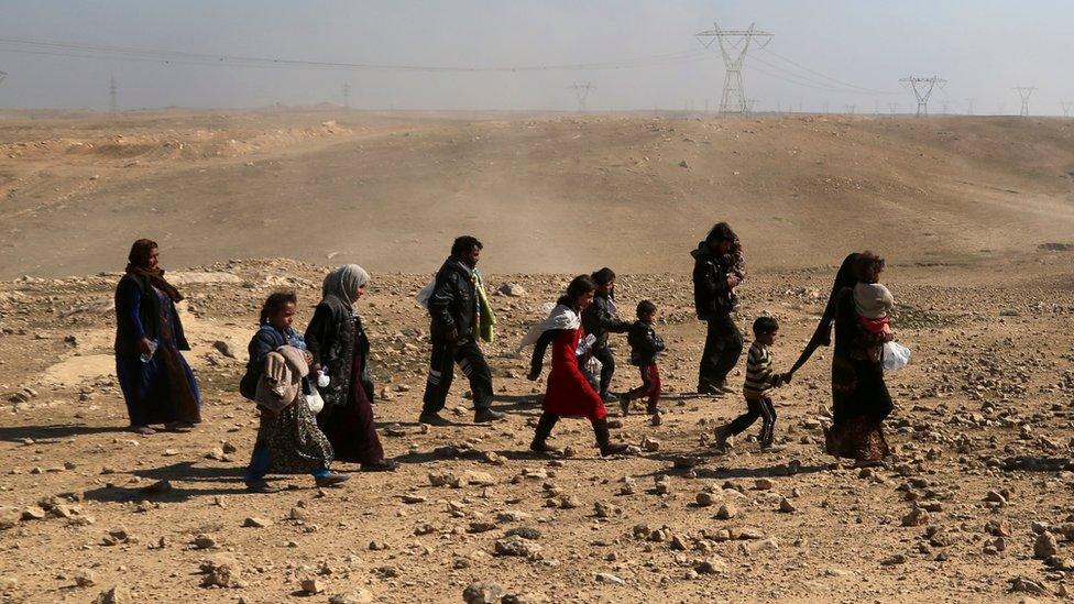 Displaced Iraqis flee their home near the western side of Mosul, 23 February