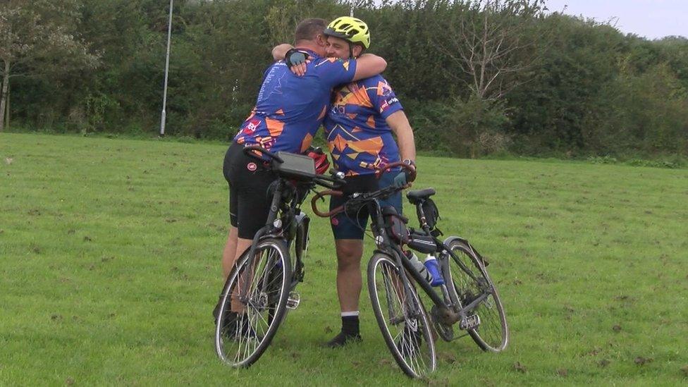 Mark Ward and Matt Price hugging on their bikes