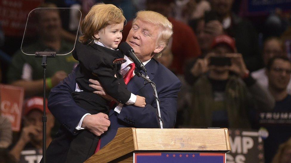 Donald Trump holds as child dressed as him during a rally at Mohegan Sun Arena in Wilkes-Barre, Pennsylvania