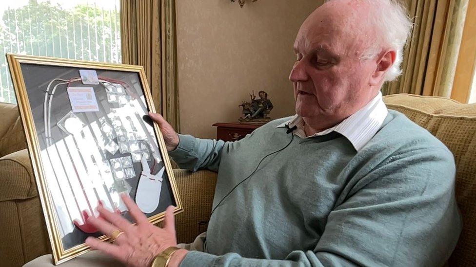 Tom Walsh holding a framed Maundy money and photographs from the day