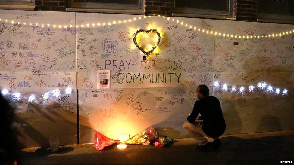 messages of condolence on a wall near a tower block