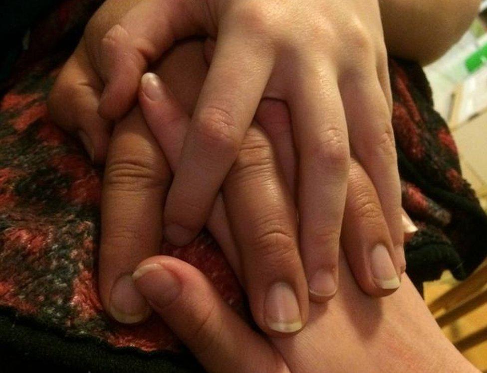 Three intertwined hands