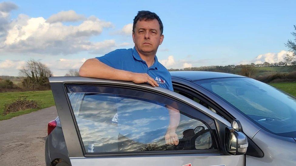 Eddie Ruskin standing by his car