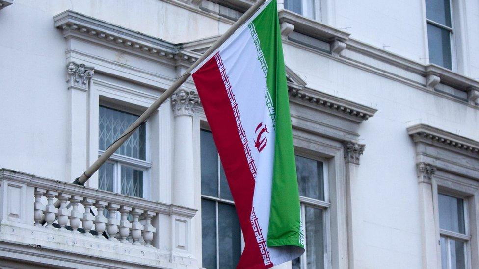 Iran's flag is seen hanging from the Iranian Embassy in central London