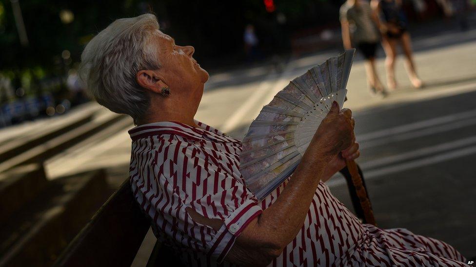 Woman uses fan to cool off in Pamplona, northern Spain, on 30 June 2015