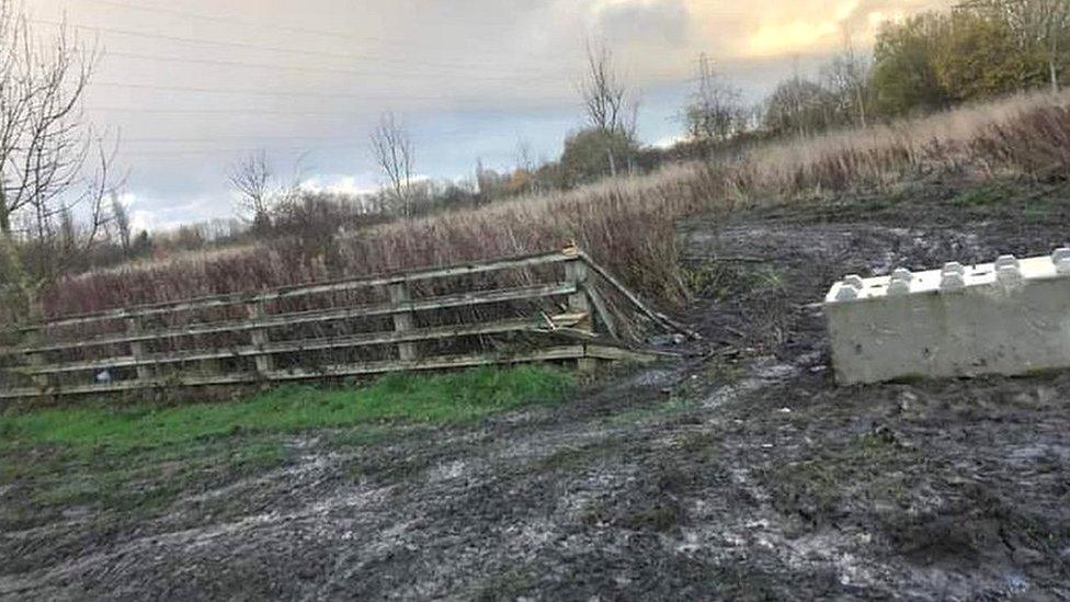 Broken fencing next to concrete bollard