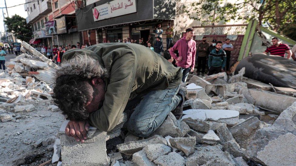 Palestinians from the same family evacuate young children, women, and the elderly alive and dead from under the rubble of their destroyed home on 16 May