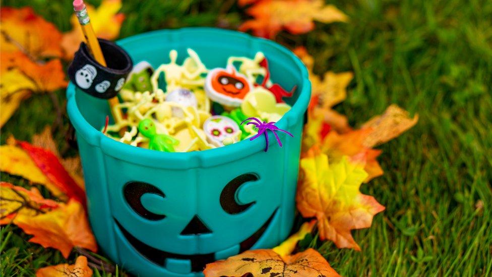 Teal pumpkin bucket with sweers in it