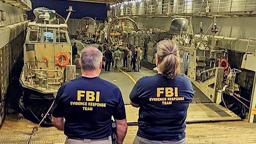 FBI agents looking at wreckage