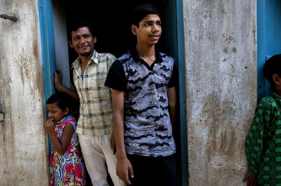 Hassan with his father and younger sister behind him