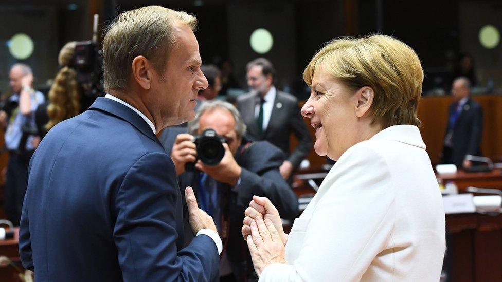 Germany's Chancellor Angela Merkel (R) speaks with European Council President Donald Tusk during an European leaders summit in Brussels on October 20, 2017