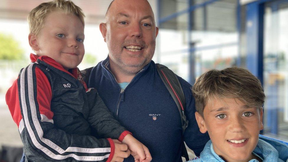 Shayne Quigg with his sons after arriving in Belfast