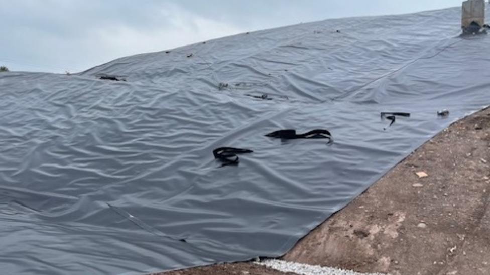 Part of the capping, which is a type of plastic cover laid over the landfill site