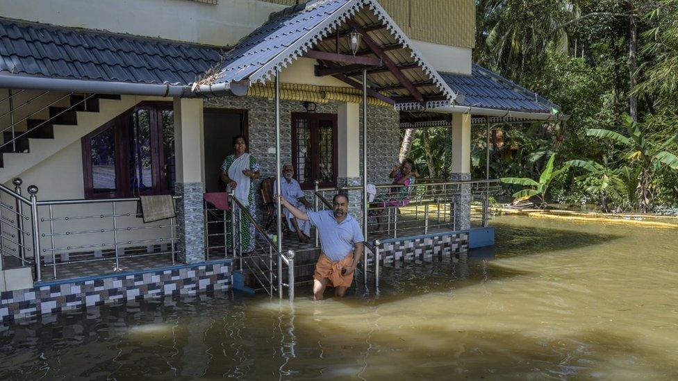 A family outside their flooded house