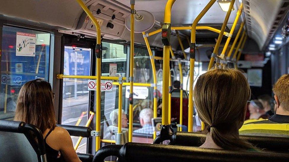 Three people pictured sitting on a bus