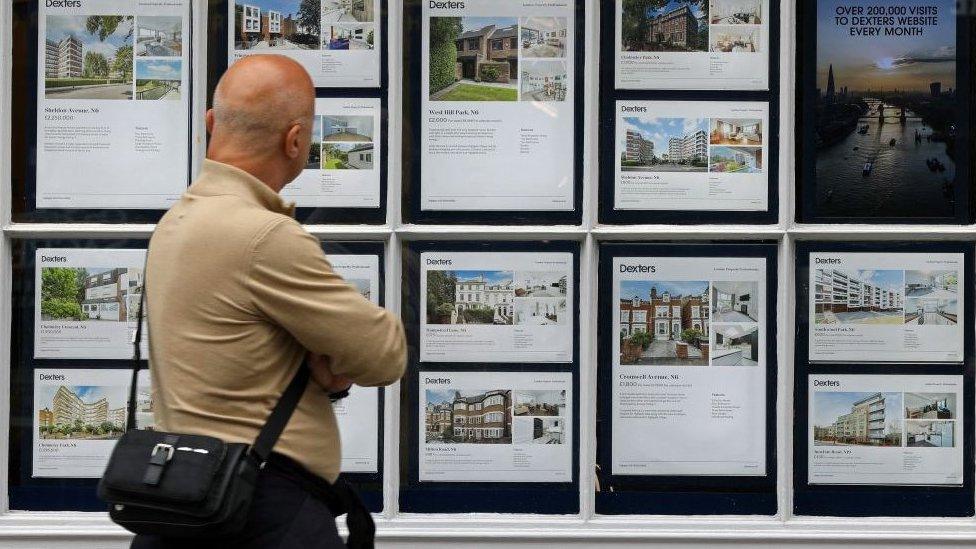 A man looks at houses for sale