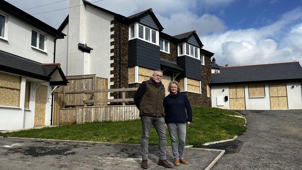 Michael and Adele stood outside the houses that have been built