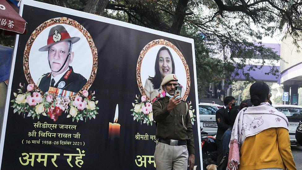 A Delhi Police personnel takes a selfie in front of the poster of The Chief of Defense staff (CDS) during the funeral procession. General Bipin Rawat, his wife Madhulika and 11 other armed forces personnel lost their lives in an Indian Air force helicopter Mi-17V5 crash in Coonoor, Tamil Nadu.