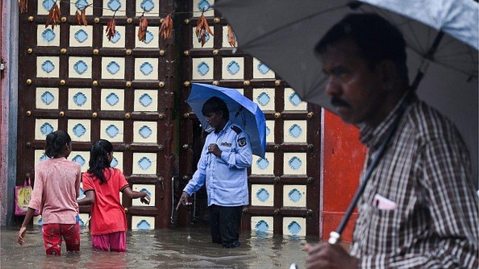 People wade through a flooded street