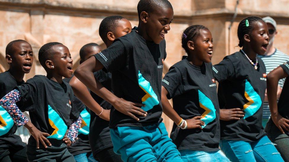 A choir of Zulu children singing and dancing