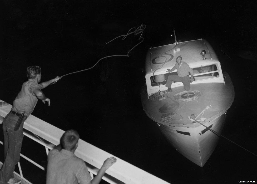 The US Coast Guard throws a rope to a boat of Cuban migrants