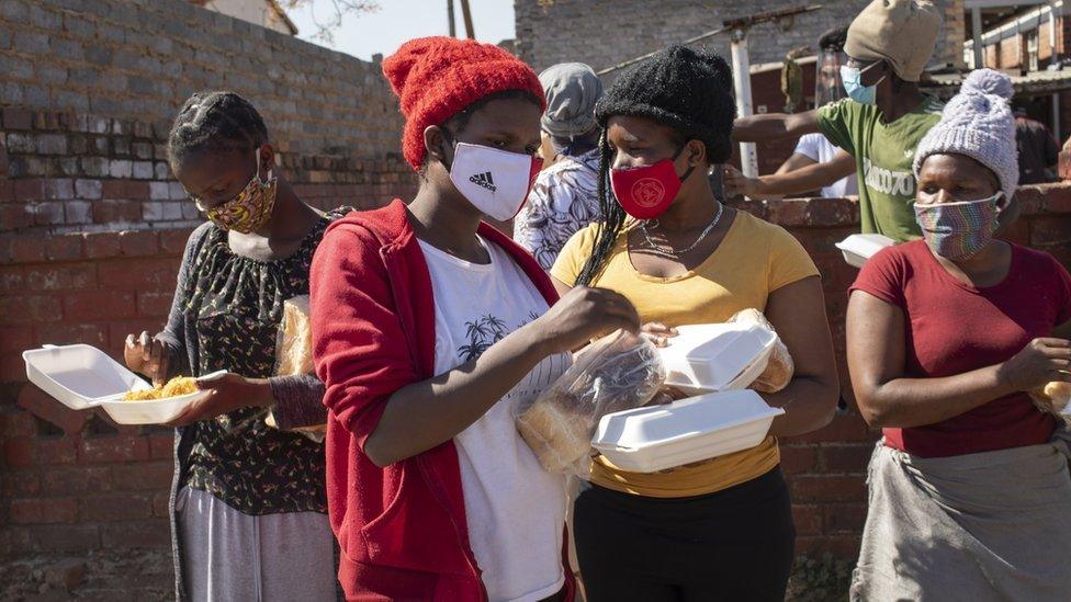 Women receive bread at a food handout during the Eid al Adha at the "Hunger Has No Religion" feeding scheme, in Johannesburg, South Africa