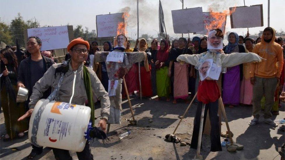 A man beats an improvised drum next to burning effigies depicting India"s Prime Minister Narendra Modi and Chief Minister of the northeastern state of Manipur Nongthombam Biren Singh, during a protest against the Citizenship Amendment Bill, in Imphal, India, February 12, 2019