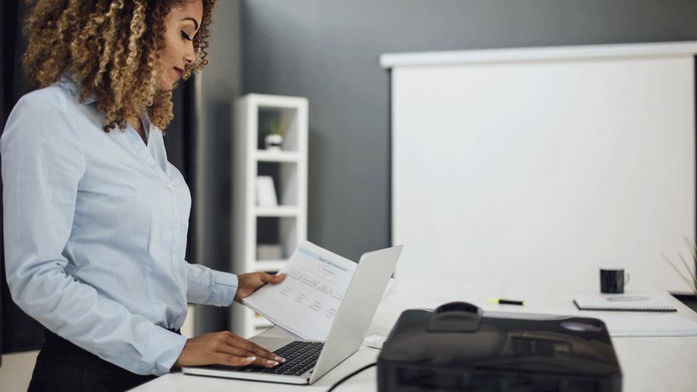 Woman standing at her desk working