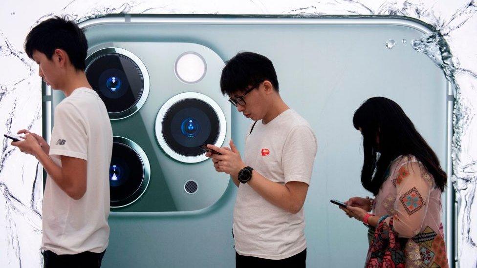 People queue to try out the new iPhone 11 Pro smartphone at an Apple store in Hong Kong on September 20, 2019.