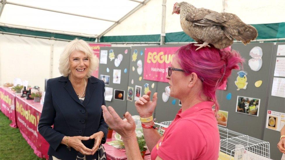 Duchess of Cornwall and Deb Howe with chicken on her head