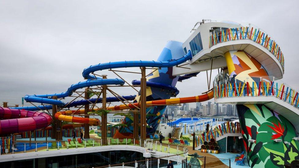 Workers place lounge chairs next to the Royal Bay pool onboard the Royal Caribbean Icon of the Seas cruise ship at Port Miami in Miami, Florida, US, on Thursday, Jan. 11, 2024.