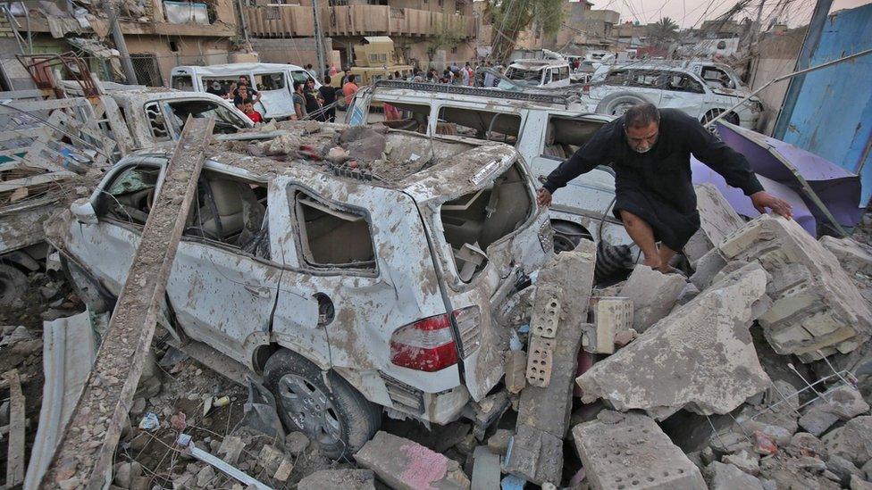 Iraqis inspect the aftermath of explosions that destroyed a mosque in Baghdad's Sadr City district (7 June 2018)