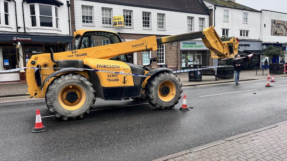 A yellow JCB cordoned off by police tape